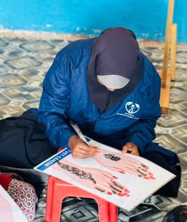 a girl learning henna design